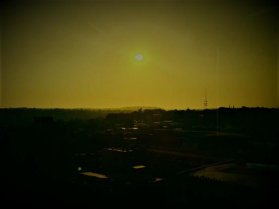 Color image of a hot, hazy sunrise over Akron, Summit County, Ohio, in the midst of a continuing heat wave/heat dome. Image shows the sun just rising over the far horizon's Chapel Hill, the sky heavy with moisture and humidity for another day near 90 degrees.