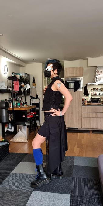 Final one of domo standing around in the living room, but this time posing with their arm on their backside and their leg out so you can see the contrast in the blue and black of their outfit, but also their leg definition. They have a cinnomoroll emoji covering their eyes.