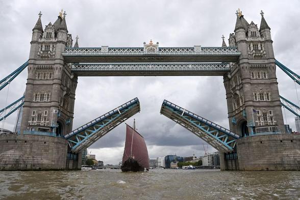Saga Farmann, a replica of an over-1000-year-old Viking longboat, sails past Tower Bridge as the bridge opens.