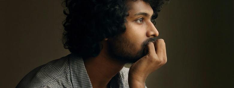 South Asian man looking thoughtful
